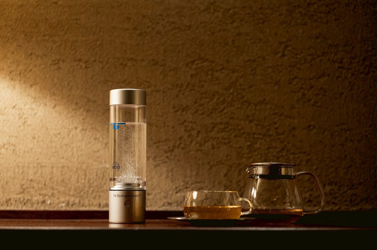 木のカウンターに置いたドクター水素ボトル+。水の中に細かな泡が見える