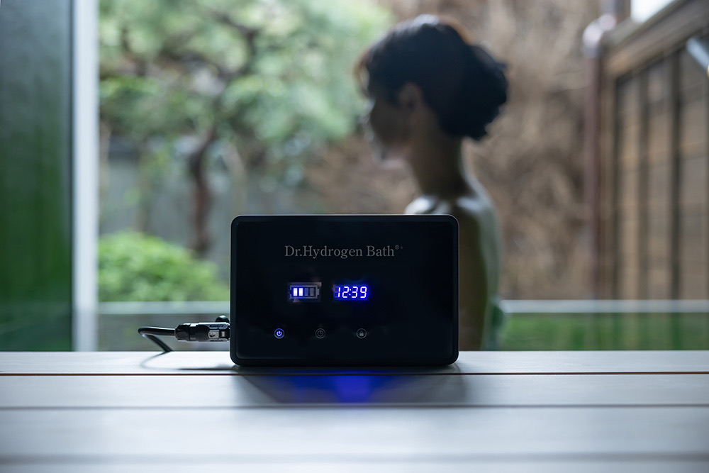 浴槽のふちに置いた、電源が入った状態のドクター水素浴+本体